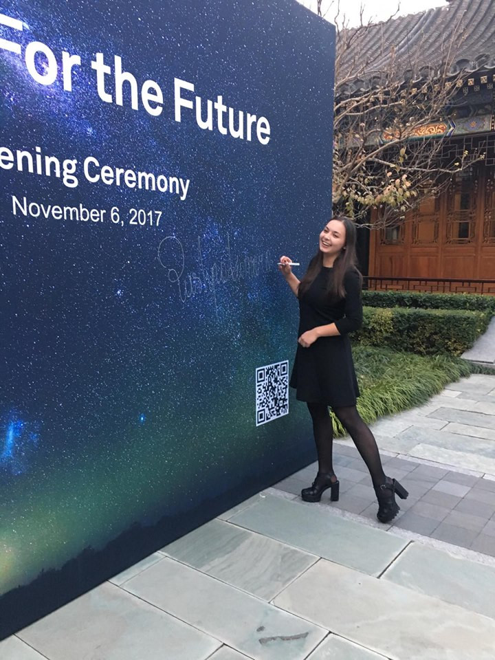 Kobieta pisze na tle z napisem "For the Future", "Opening Ceremony", "November 6, 2017". Tło to nocne niebo.